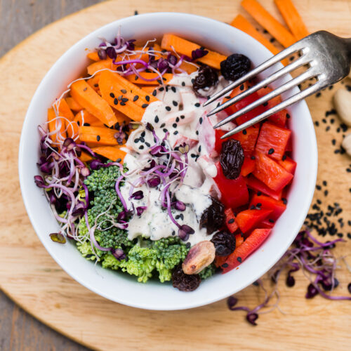 Bunter Brokkoli-Salat roh mit Cashew-Dressing, Paprika und Rosinen in einer Schüssel
