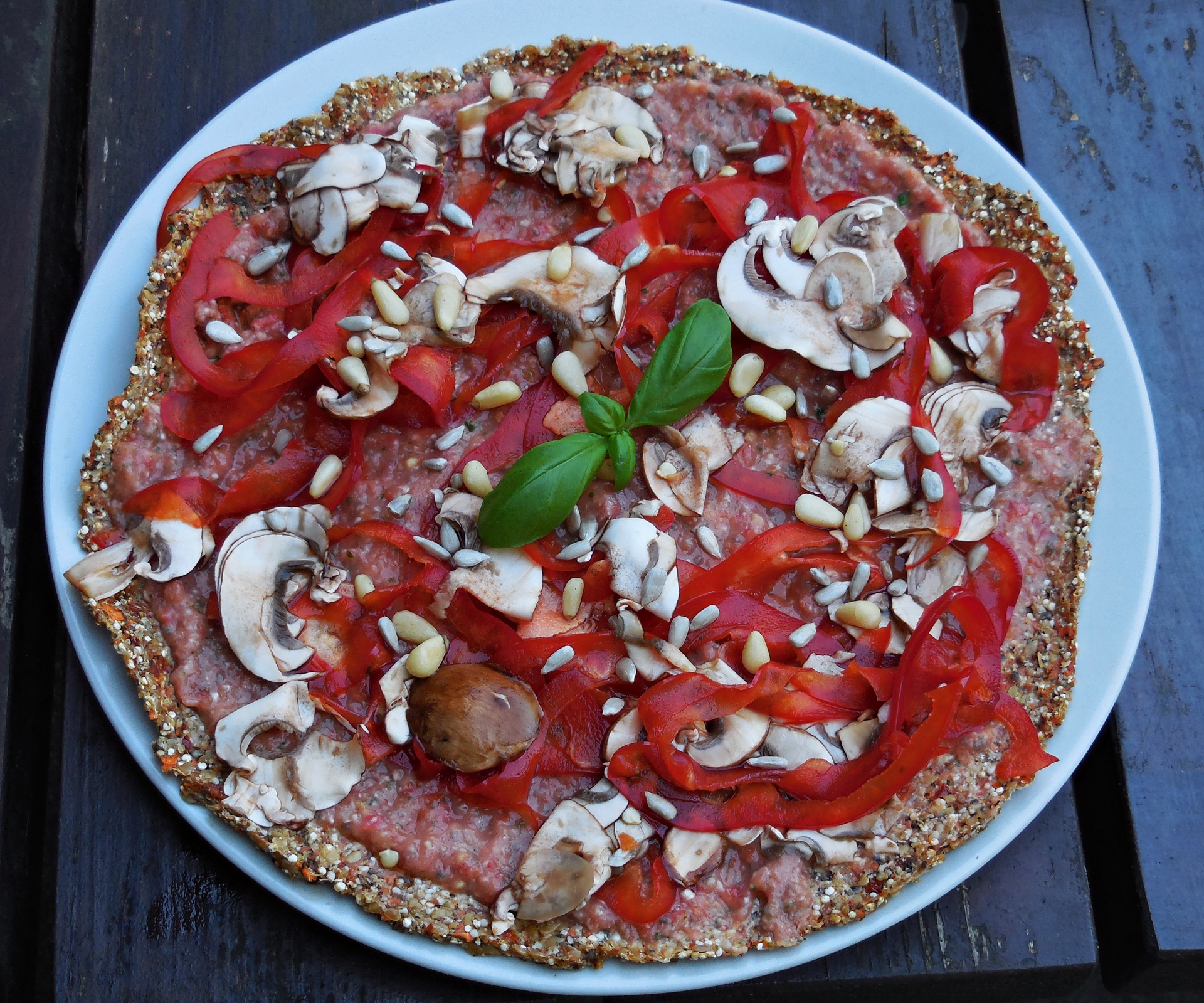 Fertig belegte Quinoa-Pizza mit Tomaten und Champignons