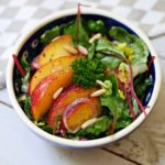 Marinierte Pfirsiche auf grünem Salat