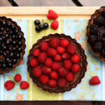 Drei dunkle Beeren-Tartes mit Johannisbeeren, Himbeeren und Brombeeren