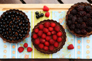 Drei dunkle Beeren-Tartes mit Johannisbeeren, Himbeeren und Brombeeren