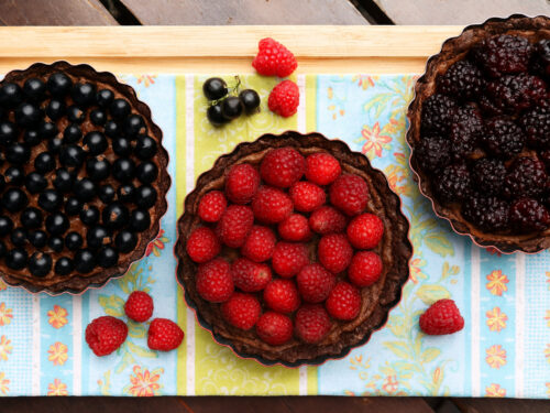 Drei dunkle Beeren-Tartes mit Johannisbeeren, Himbeeren und Brombeeren