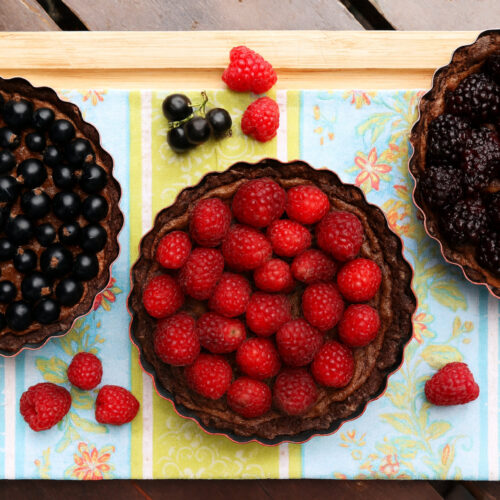 Drei dunkle Beeren-Tartes mit Johannisbeeren, Himbeeren und Brombeeren