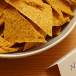 Rohkost Nachos in weisser Schale mit handgeschriebenem Kärtchen