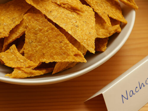 Rohkost Nachos in weisser Schale mit handgeschriebenem Kärtchen