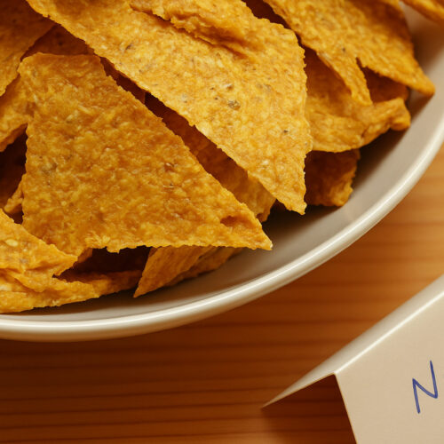 Rohkost Nachos in weisser Schale mit handgeschriebenem Kärtchen