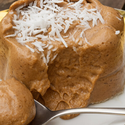 Schokoladenpudding 1 Gestürzter Schokoladenpudding mit Kokosraspeln auf dem Teller