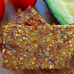 Tomaten-Pizza-Brot mit Tomate und Avocado auf dem Holzbrett