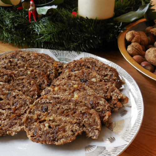 Rohkost Rezept: Weihnachtsstollen Essener Art 2 Weihnachtsstollen Essener Art in Scheiben vor dem Adventskranz
