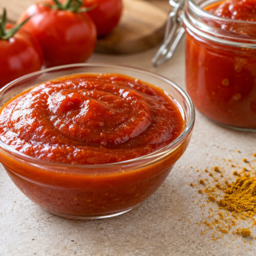 Roher Curry-Ketchup aus Datteln und getrockneten Tomaten im Glas